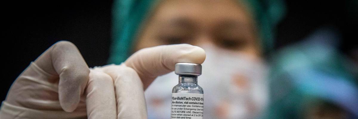 A nurse holds a vial of Pfizer vaccine