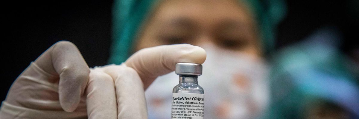 A nurse holds a vial of Pfizer vaccine