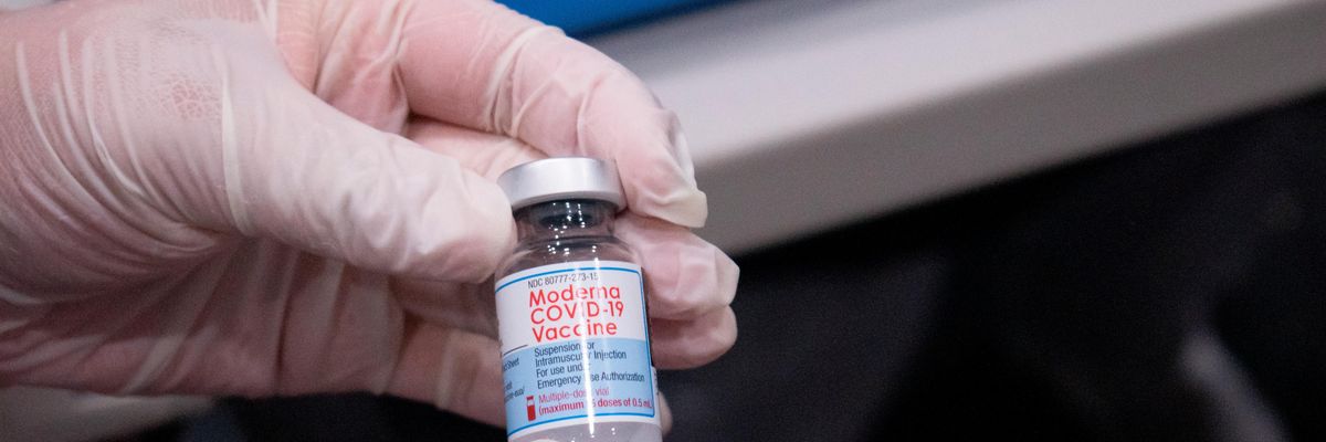 A nurse holds a vial of the Moderna vaccine