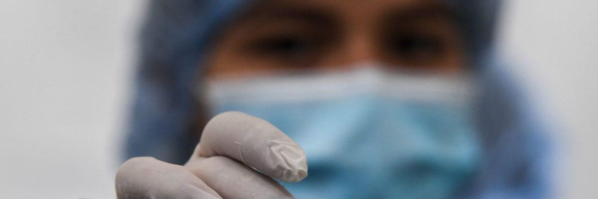 A nurse holds a vial of the Pfizer-BioNTech vaccine