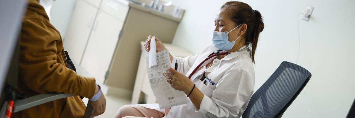 A nurse sits next to a patient.