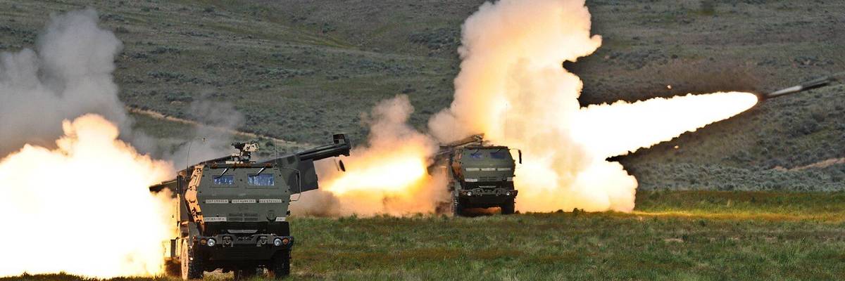 a pair of HIMARS launchers fire their rockets