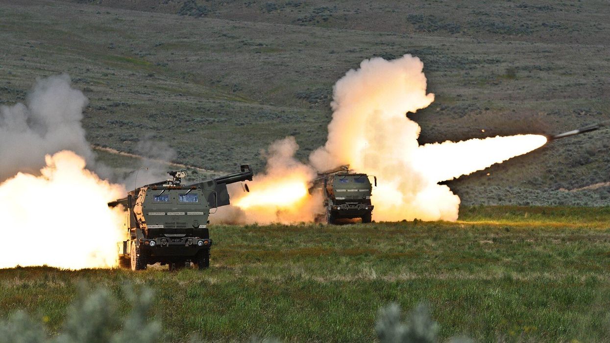 a pair of HIMARS launchers fire their rockets