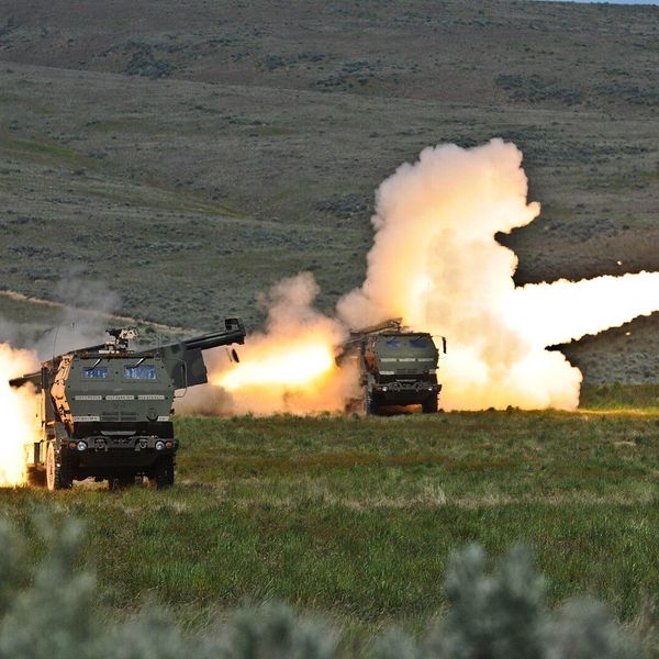 a pair of HIMARS launchers fire their rockets