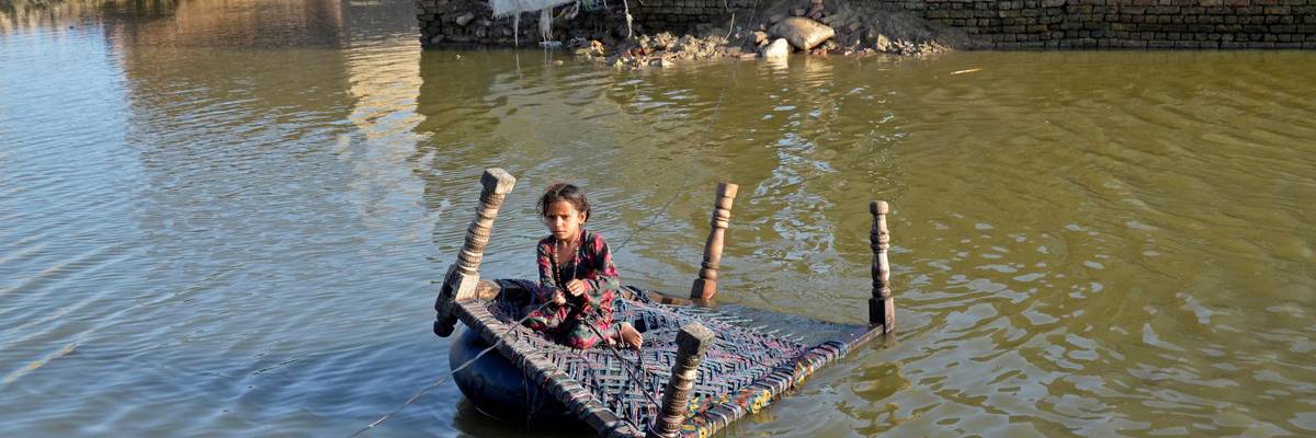 A Pakistani girl crosses a flooded street