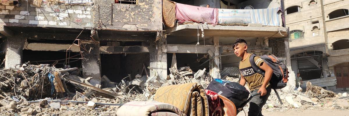 A Palestinian boy flees with his belongings