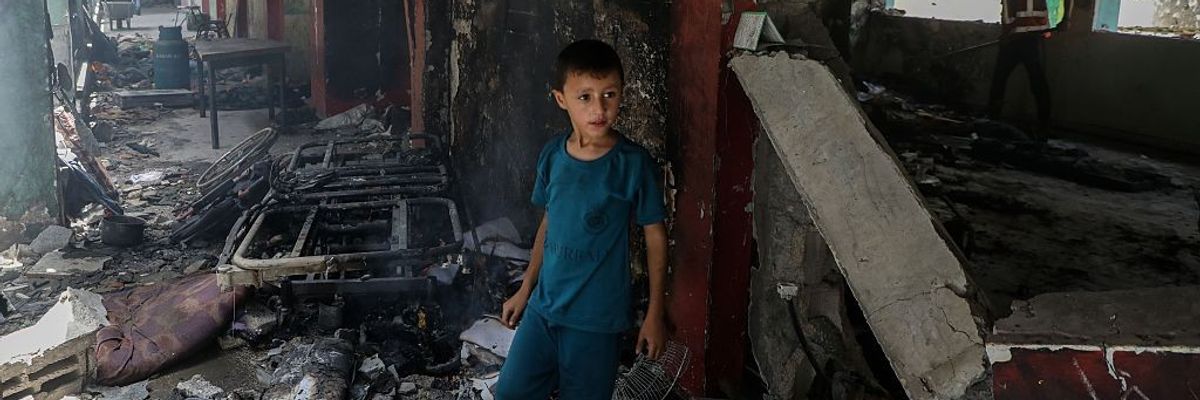 A Palestinian boy is seen at the Fahmi Al-Jarjawi school after an Israeli airstrike