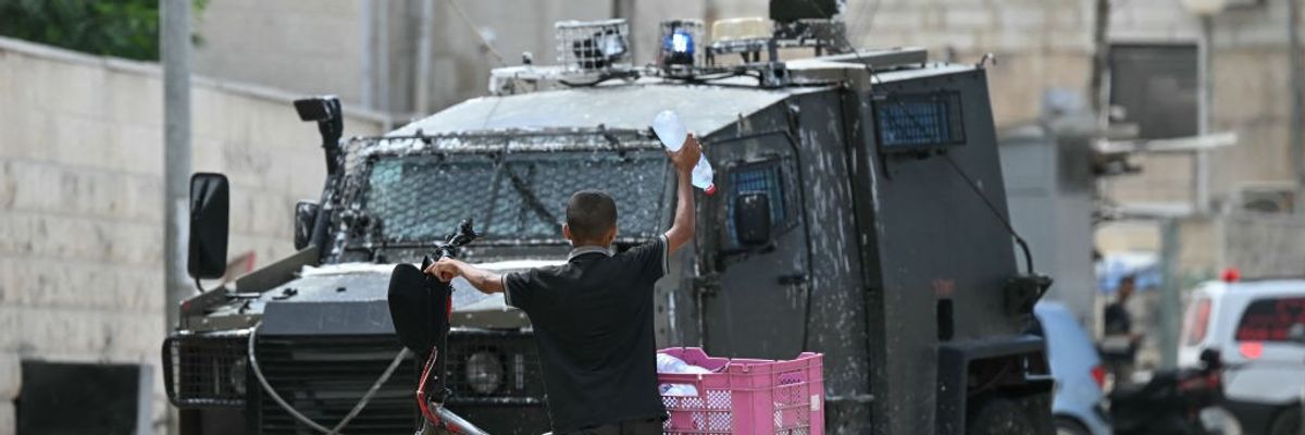 A Palestinian boy near an Israeli military vehicle