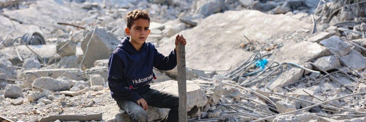A Palestinian boy sits amid the ruins of a home bombed by Israeli forces in Jabalia, Gaza.