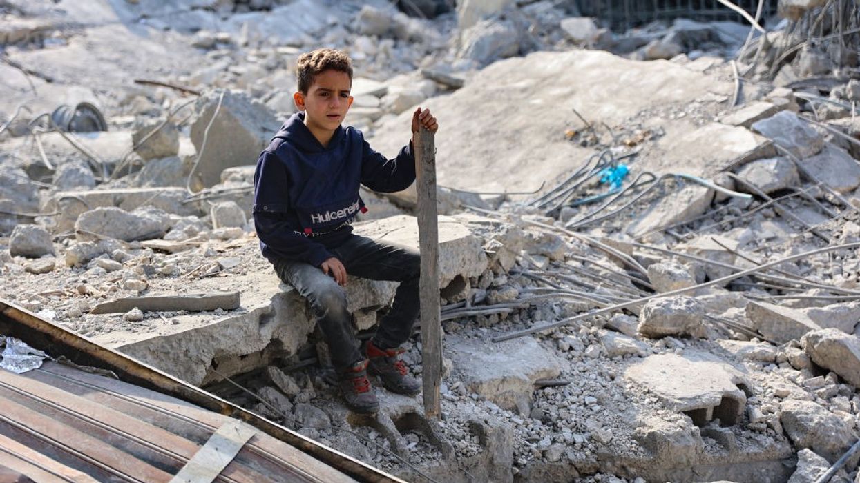 A Palestinian boy sits amid the ruins of a home bombed by Israeli forces in Jabalia, Gaza.