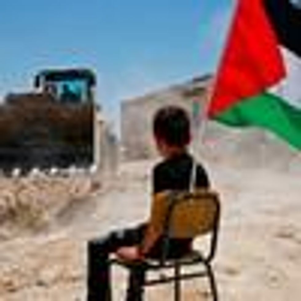 A Palestinian boy sits on a chair with a national flag as Israeli authorities demolish a school site in the village of Yatta, south of the West Bank city of Hebron on July 11, 2018. (Photo: Hazem Bader/AFP via Getty Images)