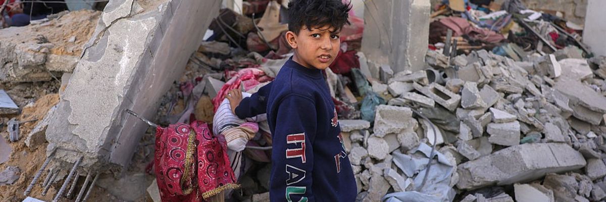 A Palestinian boy walks amid the rubble of Gaza