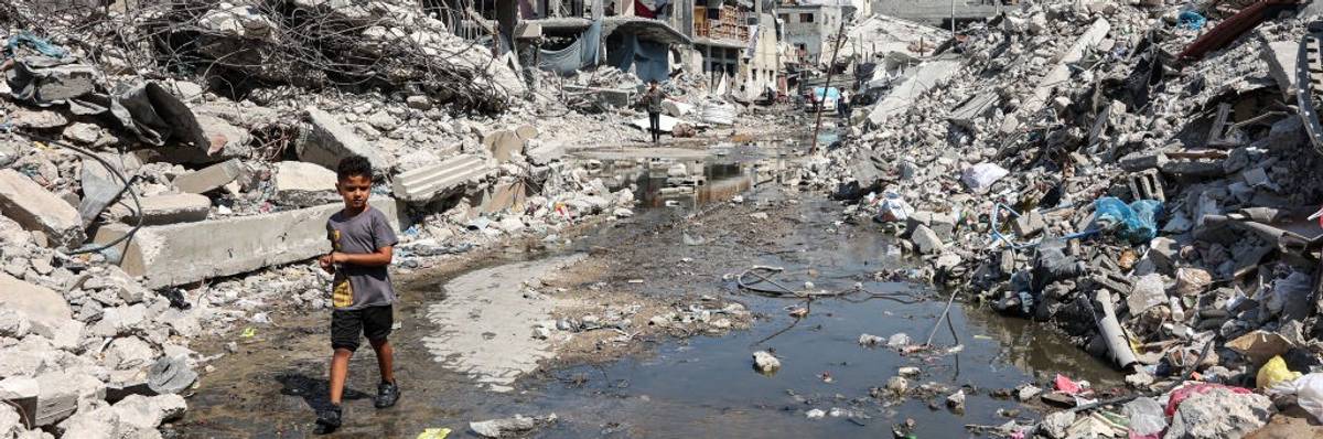 A palestinian boy walks through a puddle of sewage water in the Jabalia refugee camp in Gaza