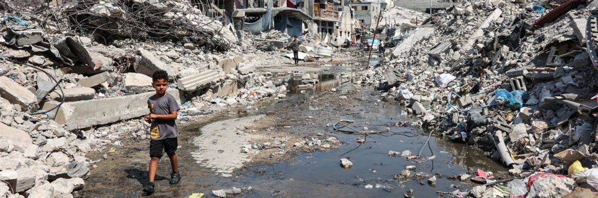 A palestinian boy walks through a puddle of sewage water in the Jabalia refugee camp in Gaza