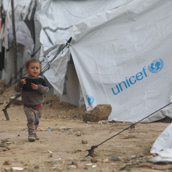 A Palestinian child walks among storm-damaged tents provided by UNICEF in Gaza