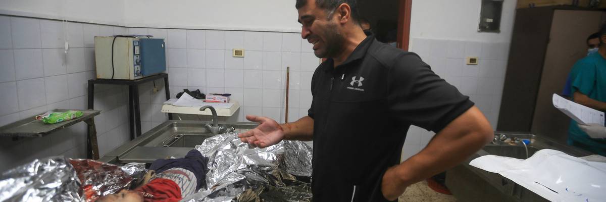 A Palestinian father mourns his dead child at Gaza's Al-Shifa Hospital