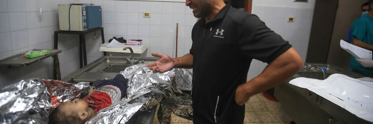 A Palestinian father mourns his dead child at Gaza's Al-Shifa Hospital