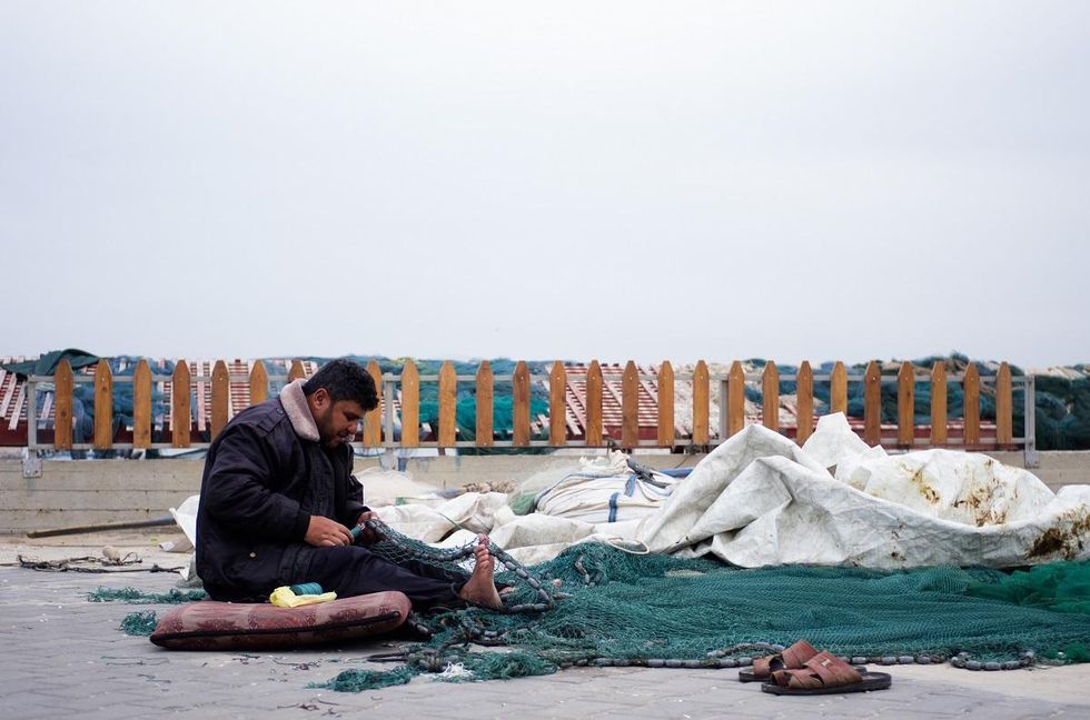 A Palestinian fishermen prepares his nets in Gaza's port before going out to sea. Photo by Kaamil Ahmed/Mongabay.