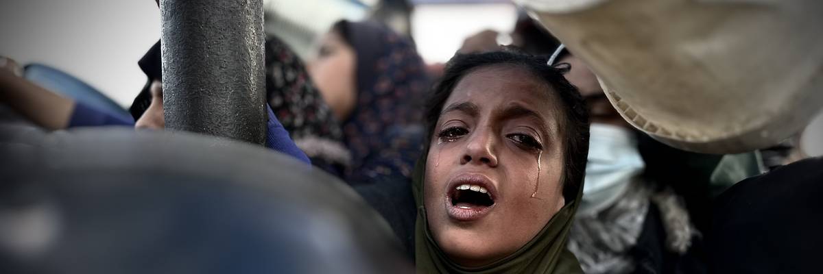 A Palestinian girl cries as she waits in line to receive meals distributed by charities in Khan Yunis, Gaza.