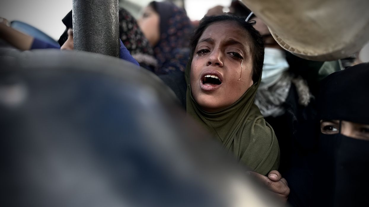A Palestinian girl cries as she waits in line to receive meals distributed by charities in Khan Yunis, Gaza.