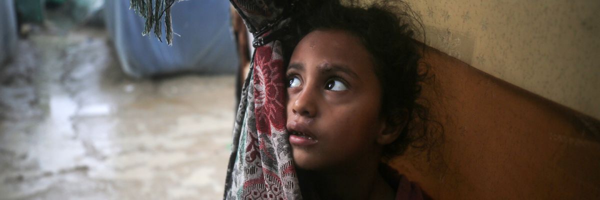 A Palestinian girl stands at a refugee camp