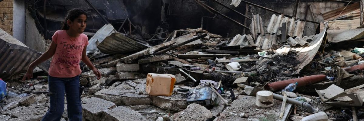A Palestinian girl walks amid the rubble of a destroyed building in the West Bank