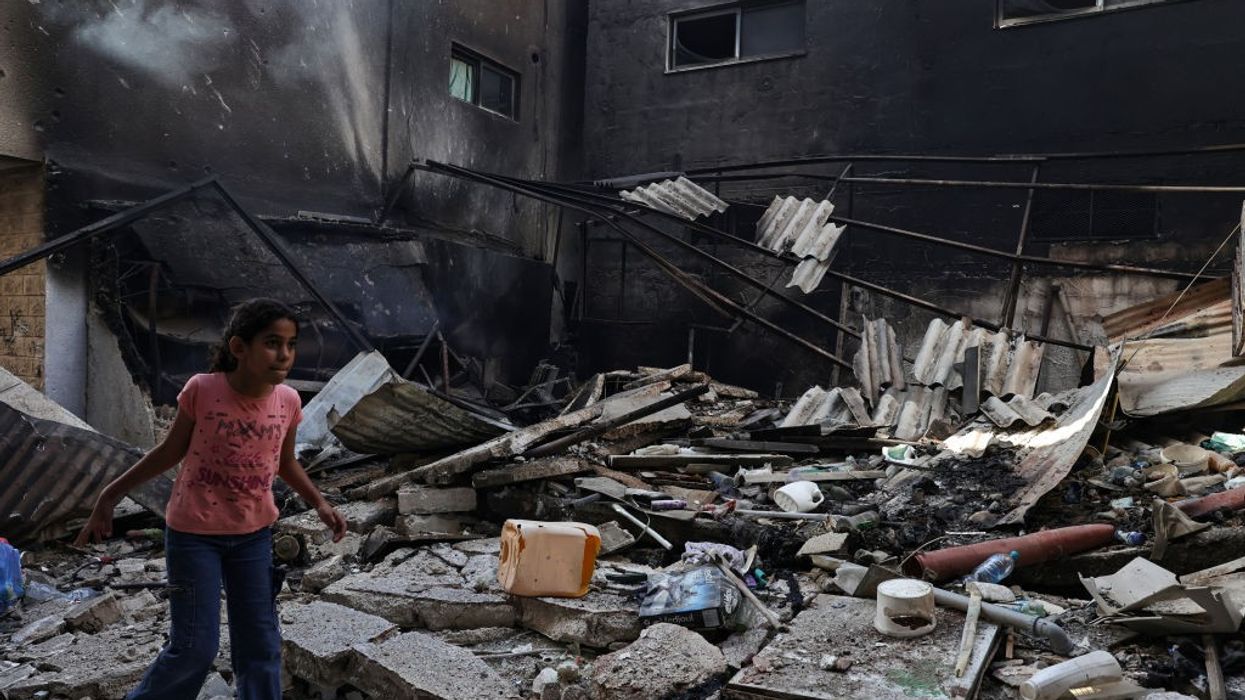 A Palestinian girl walks amid the rubble of a destroyed building in the West Bank