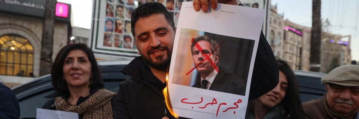 A Palestinian man burns an image of U.S. Secretary of State Antony Blinken