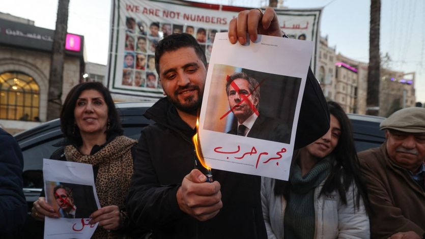 A Palestinian man burns an image of U.S. Secretary of State Antony Blinken