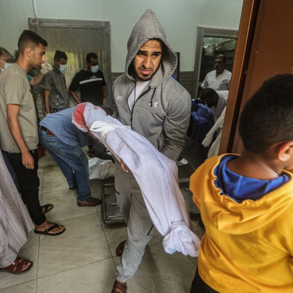 A Palestinian man carries a dead child in Khan Younis
