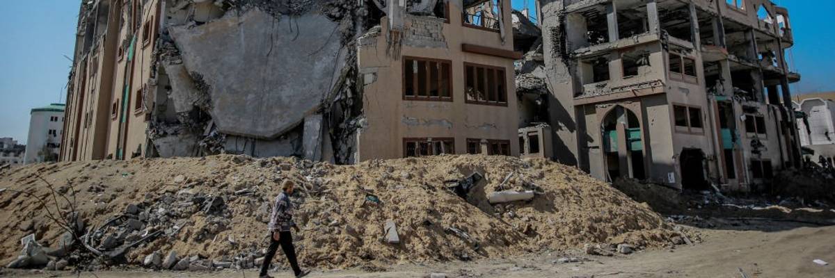A Palestinian man walks past the ruins of Islamic University in Gaza City