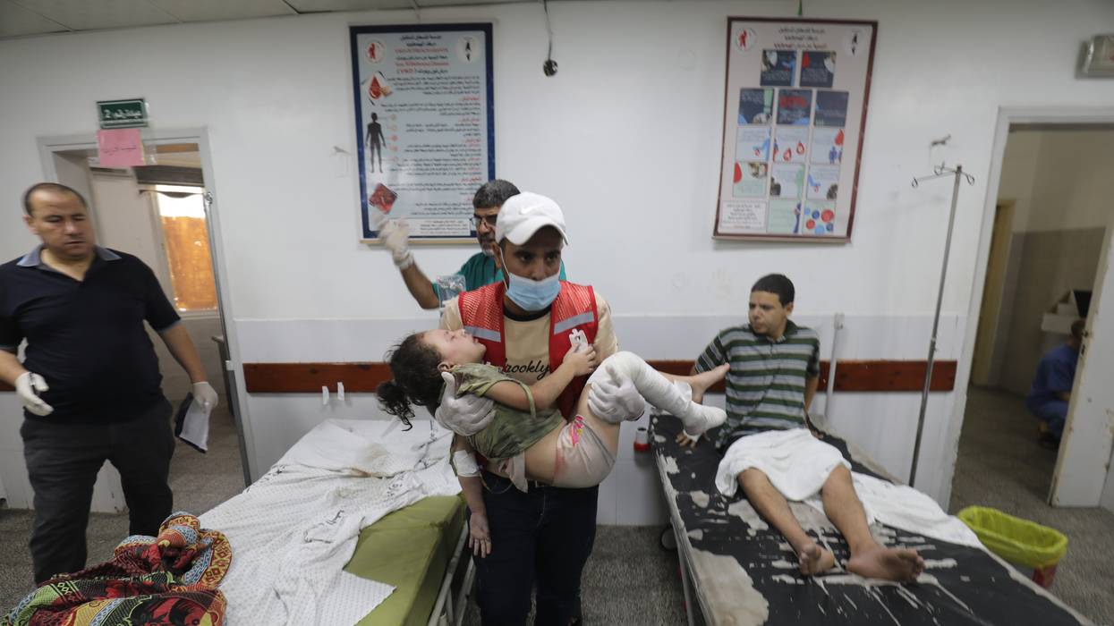 A Palestinian medic carries a wounded girl in a Gaza hospital