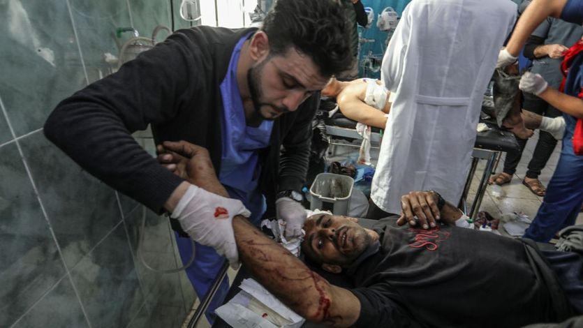 A Palestinian medic treats a man injured in an Israeli attack