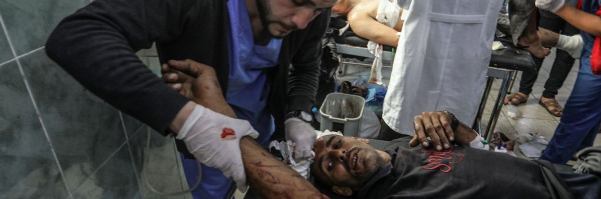 A Palestinian medic treats a man injured in an Israeli attack