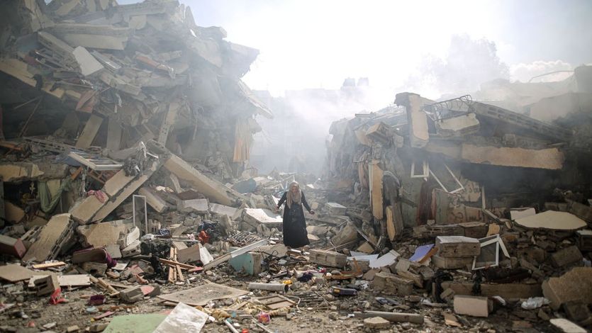 A Palestinian resident walks amid near the rubble of buildings after Israeli bombings in Gaza