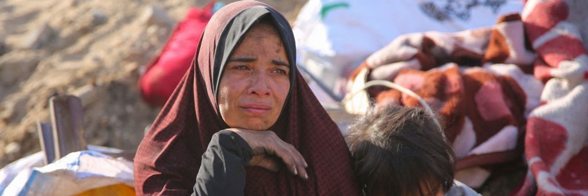 A Palestinian woman cries as she sits amidst the rubble of Gaza after Israeli attack