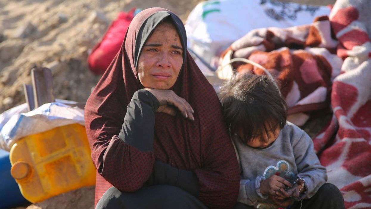 A Palestinian woman cries as she sits amidst the rubble of Gaza after Israeli attack