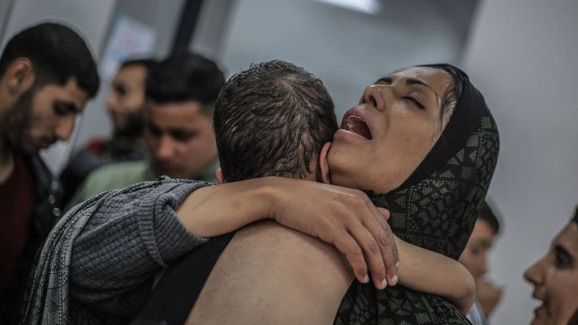 A Palestinian woman hugs a child