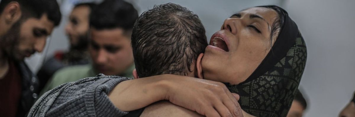 A Palestinian woman hugs a child