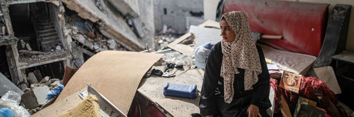 A Palestinian woman surveys the destruction of her home and neighborhood in Gaza