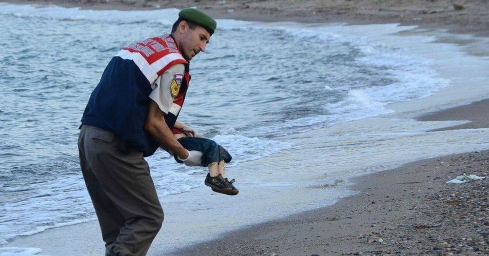 A paramilitary police officer carries the lifeless body of three-year-old Aylan Kurdi after he drowned when the boat he and his family members were in capsized near the Turkish resort of Bodrum early Wednesday, Sept. 2, 2015. (Photo: Nilufer Demir/DHA)