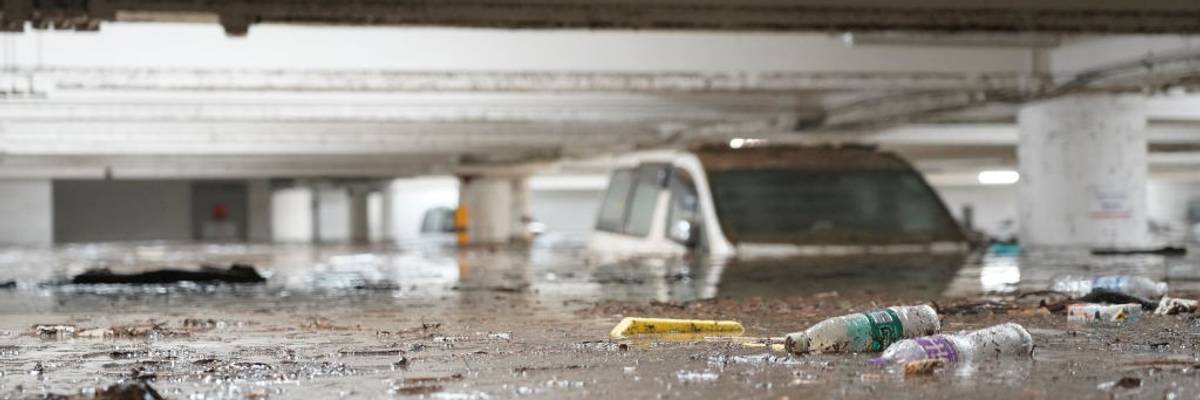 A partially submerged car sits in a parking lot.