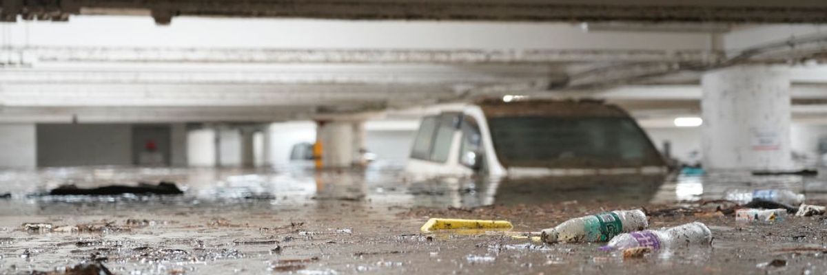 A partially submerged car sits in a parking lot.