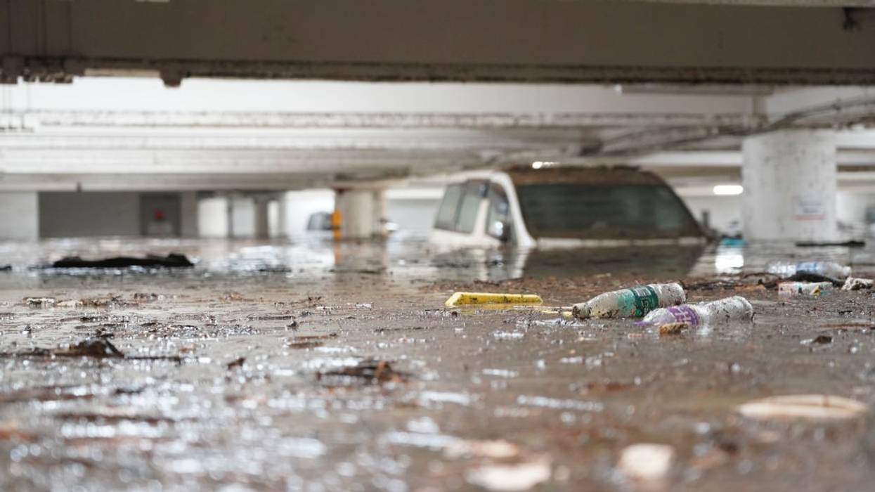 A partially submerged car sits in a parking lot.