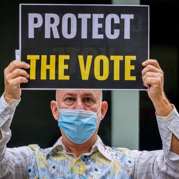 A participant holding a Protect The Vote sign outside NBC
