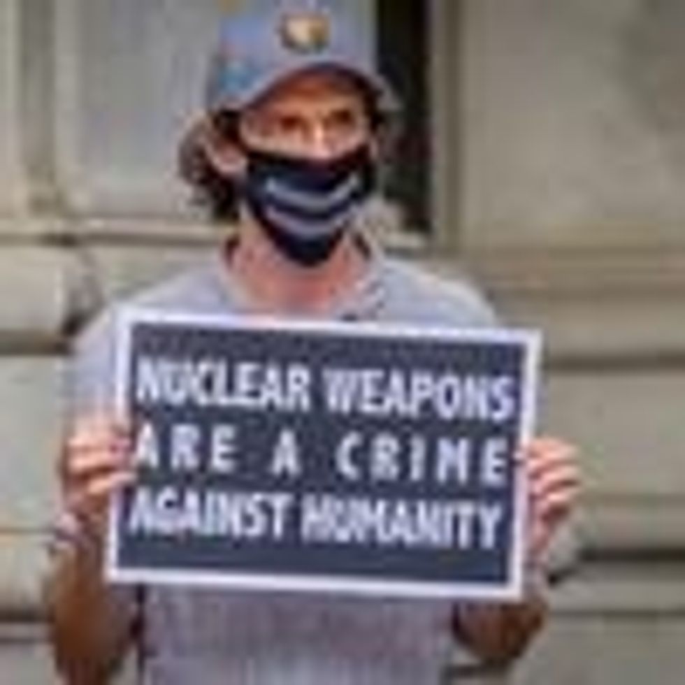 A participant holds a sign during a rally outside the David N. Dinkins Municipal Building in Manhattan on the 75th anniversary of the bombing of the city of Hiroshima