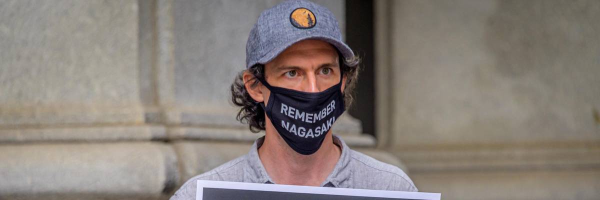 A participant holds a sign during a rally outside the David N. Dinkins Municipal Building in Manhattan on the 75th anniversary of the bombing of the city of Hiroshima