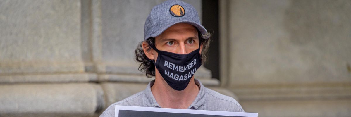 A participant holds a sign during a rally outside the David N. Dinkins Municipal Building in Manhattan on the 75th anniversary of the bombing of the city of Hiroshima