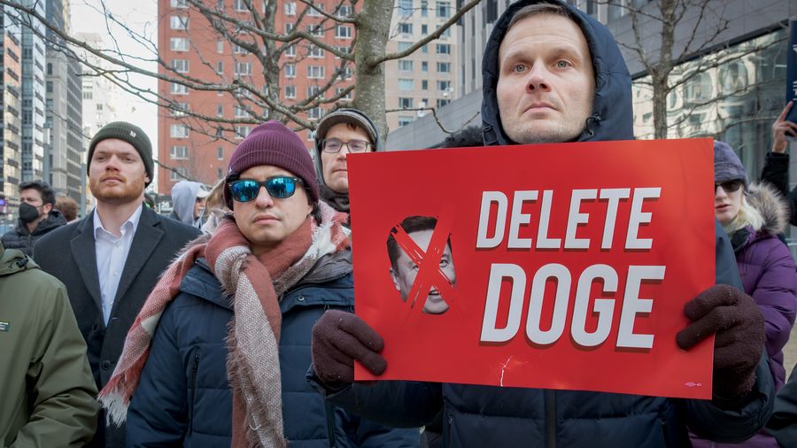 A participant is seen holding a sign at the protest