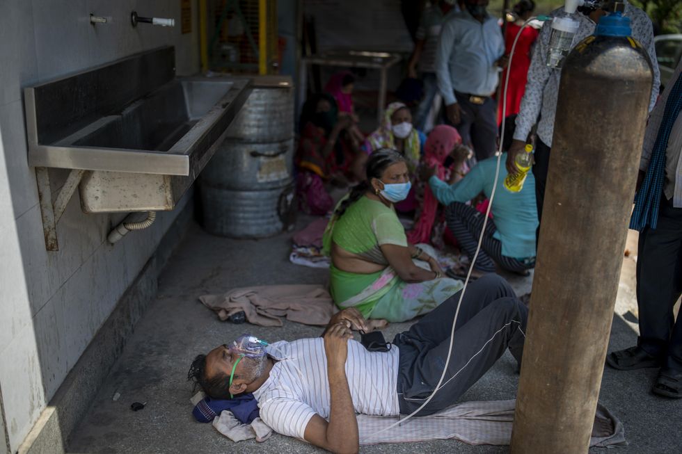 A patient receives oxygen outside a gurdwara, a Sikh house of worship, in New Delhi, India, Saturday. India's medical oxygen shortage has become so dire that this gurdwara began offering free breathing sessions with shared tanks to COVID-19 patients waiting for a hospital bed.